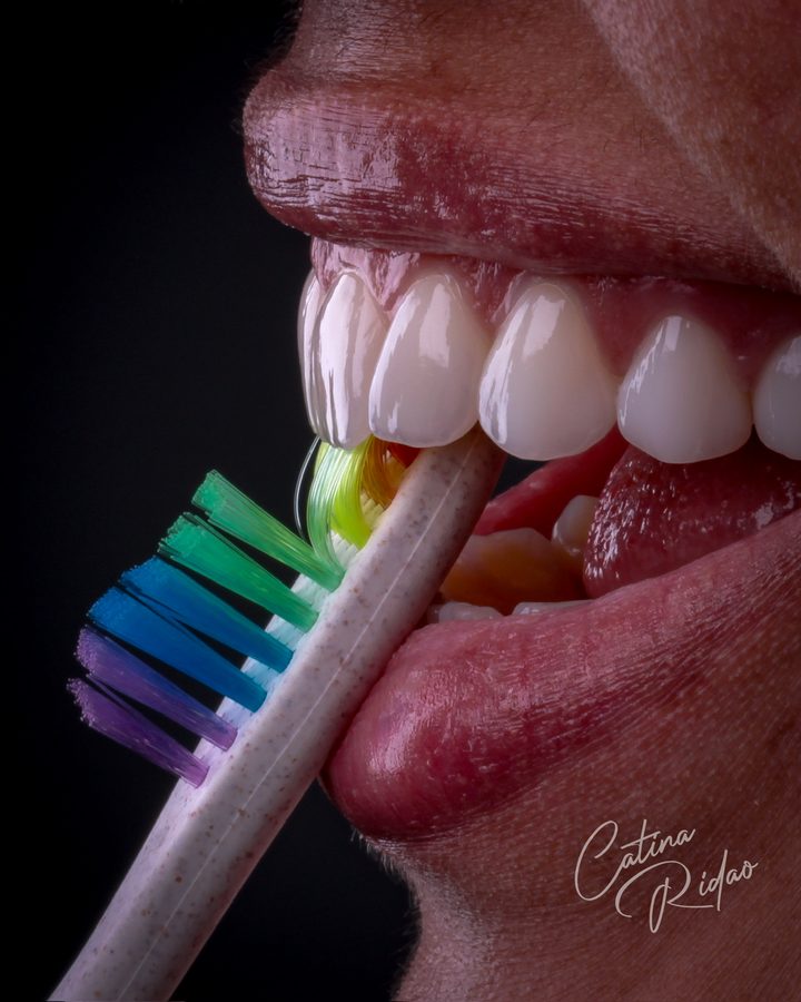 Cepillo de dientes de colores sobre una sonrisa, fotografía creativa