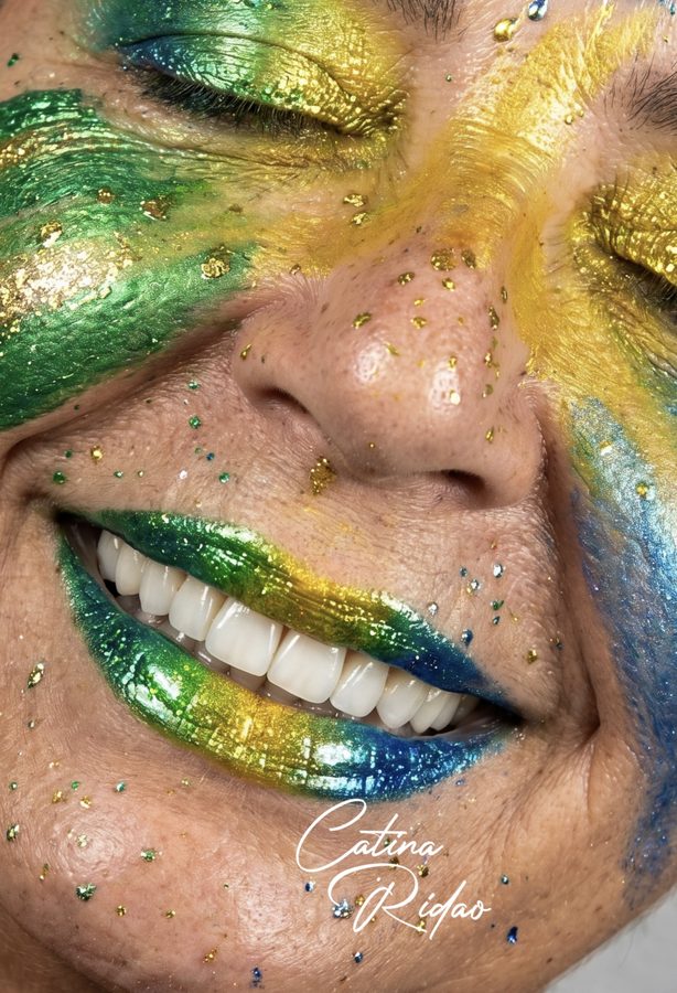 Rostro pintado de colores con labios metalizados, fotografía dental creativa