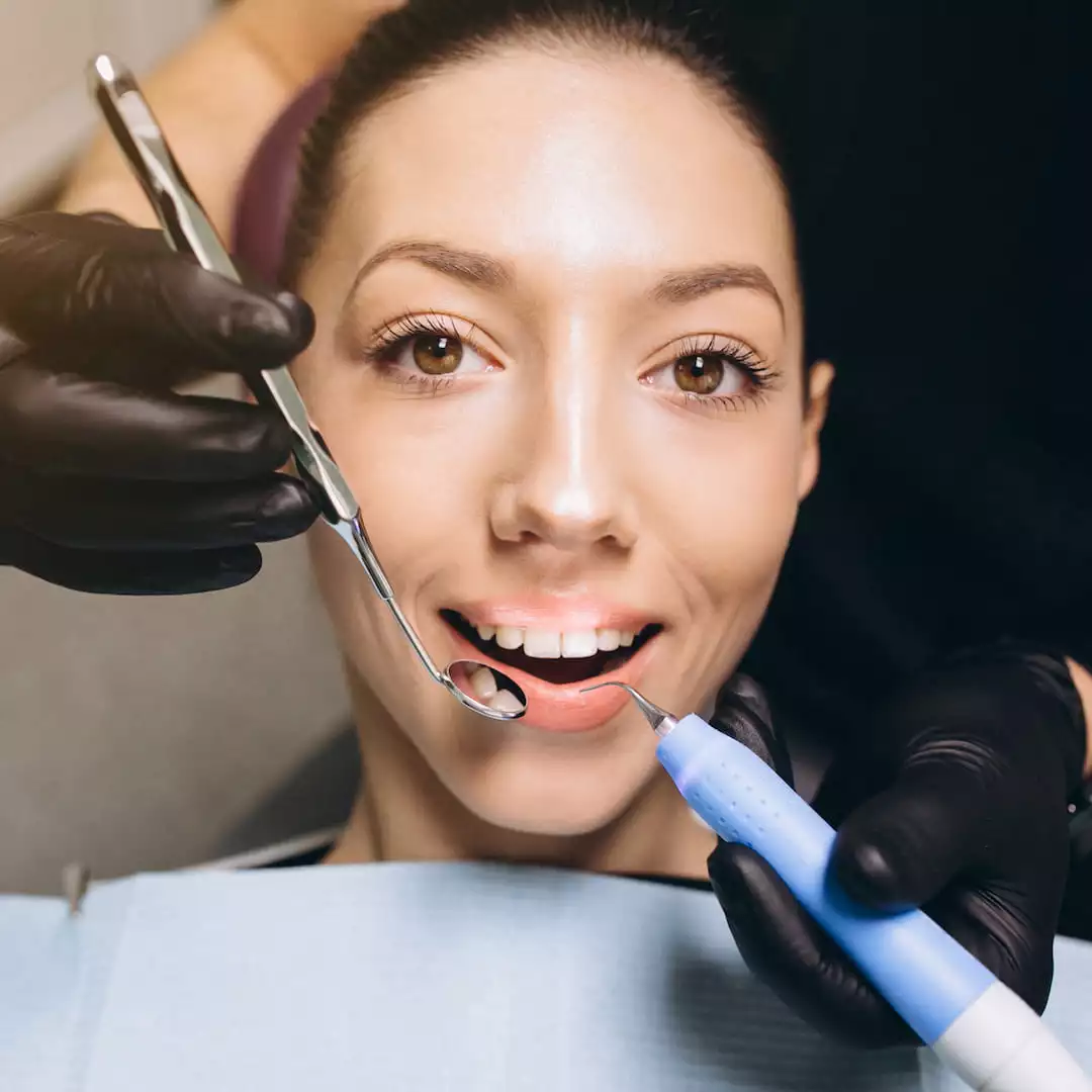 la imagen muestra a una mujer recibiendo el servicio de Tratamientos de odontología general